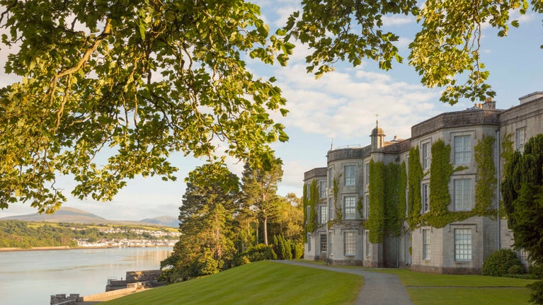 The house at Plas Newydd, Anglesey, on the banks of the Menai Strait with autumn trees in the foreground